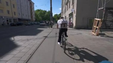 29 Nisan 2025. Münih, Almanya. Fahrradfahrt durch die Muenchner Innenstadt bei warmem Wetter. Perspektif vom Lenker zeigt dichten Radverkehr, modernes Stadtleben und klimafreundliche Mobilitaet