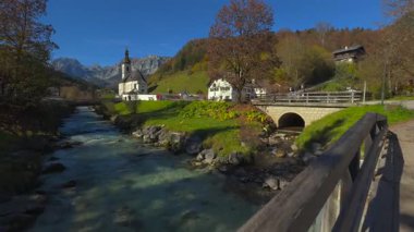 Almanya, Ramsau 'daki Aziz Sebastian Kilisesi. Güneşli gökler vadiden ve görkemli dağlardan akan nehirler seyahat ve turizm için mükemmel manzaralar yaratıyor. Kirche Ramsau bei Berchtesgaden 'de.. 