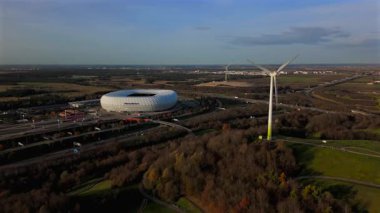 Windrad Froettmaninger Muellberg ve Allianz Arena Muenchen, Deutschland Luftaufnahme. Frottmaninger Berg mit Blick auf Allianz Arena Luftbildansicht. Windkraftanlage Freimann. Münih Futbol Arenası