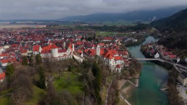 Almanya, Fuessen 'in nefes kesici hava manzarası, St. Mang Kilisesi, görkemli Hohes Schloss ve Lech Nehri' nin sergilenmesi. Büyüleyici ortaçağ kasabası yemyeşil ve Bavyera Alpleriyle çevrili.. 