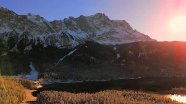 Alman Bavyera Alpleri 'ndeki kar kaplı ağaç tepelerinde nefes kesen hava manzarası, Zugspitze kitsif sergileniyor. Zugspitze Gipfel Wetterstein Dağları 'nın en yüksek zirvesi ve Almanya' nın en yüksek dağı. 