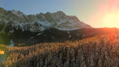 Alman Bavyera Alpleri 'ndeki kar kaplı ağaç tepelerinde nefes kesen hava manzarası, Zugspitze kitsif sergileniyor. Zugspitze Gipfel Wetterstein Dağları 'nın en yüksek zirvesi ve Almanya' nın en yüksek dağı. 
