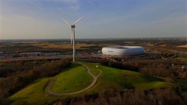 Froettmaninger Tepesi 'nin hava manzarası, rüzgar türbini ve Münih' teki Allianz Arena manzarası. Freimann rüzgar santrali ve Münih futbol sahası yukarıdan ele geçirildi. 
