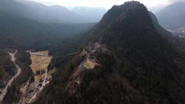 Avusturya, Tyrol, Reutte yakınlarındaki Ehrenberg Kalesi 'nin havadan görüntüsü. Ortaçağ Ehrenberg kalıntıları, Schlosskopf Kalesi ve çarpıcı Lechtal Alpleri 'ndeki ikonik Highline179 asma köprüsü.. 