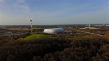 Windrad Froettmaninger Muellberg ve Allianz Arena Muenchen, Deutschland Luftaufnahme. Frottmaninger Berg mit Blick auf Allianz Arena Luftbildansicht. Windkraftanlage Freimann. Münih Futbol Arenası