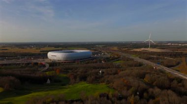 Windrad Froettmaninger Muellberg ve Allianz Arena Muenchen, Deutschland Luftaufnahme. Frottmaninger Berg mit Blick auf Allianz Arena Luftbildansicht. Windkraftanlage Freimann. Münih Futbol Arenası