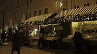 14 Aralık 2024. Landshut, Almanya. Advent Town Landshut Akşamları, ziyaretçiler büyülü atmosferde Christkindlmarkt ve zanaat pazarının tadını çıkarırken eski şehir merkezi şenlikli ışıklarla parlıyor