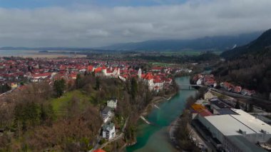 Fussen 'in kırmızı çatıları, Gotik mimarisi ve tarihi simgeleri olan eski kasabasının insansız hava aracı görüntüleri. Lech Nehri, Bavyera 'nın zengin kültürel mirasını ön plana çıkararak, pitoresk bir manzara boyunca esiyor..