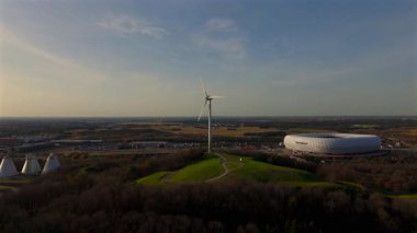Rüzgâr türbinli Froettmaninger Mullberg 'in hava görüntüsü ve Münih' teki Allianz Arena 'nın net bir görüntüsü. Freimann rüzgar türbini ve Münih futbol arenasının kuş bakışı perspektifi.