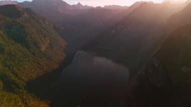 Almanya 'daki Koenigssee' nin havadan görünüşü çarpıcı sonbahar renkleri ve gölün üzerinde altın gün batımı sergiliyor. Çevrelenmiş görkemli Alpler, Bavyera Berchtesgadener 'da sakin sonbahar manzarası saf doğal güzelliktir.