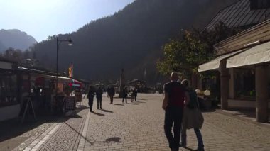 20 Ekim 2024, Almanya Schoenau am Koenigssee. Ünlü göl kenarındaki sevimli Bavyera köyü. Popüler turistik yerler, dağlık manzaralar, tarihi sokaklar ve rahatlatıcı atmosfer. Şehirde dolaşan insanlar. 