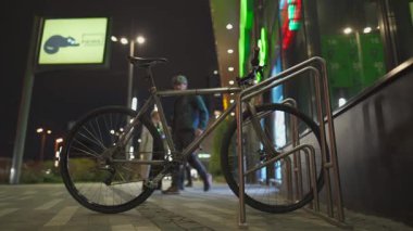 Banliyö çalışanı süpermarketten girer ve akşam saatlerinde bisikletini park yerinden alır. Şehir Bisiklet Altyapısı teması. Bisikletli teslimatçı siparişi aldı ve müşteriyi Velocipede 'de taşıdı..