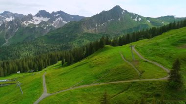 Yazın Alpler 'de kayak merkezinde bisiklet süren hava manzaralı bisikletçi. Bisikletçi Almanya 'nın Bavyera dağlarındaki dağ tatil beldesinde çakıllı bisikletle seyahat ediyor. Alp yamaçlarında bisiklet gezileri