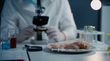 Genç erkek beslenme uzmanı gıda ürünlerini laboratuvarda test ediyor. Genetik mühendisliği, genetik modifikasyon, GDO ve gen manipülasyonu kavramı. Laboratuvarda kültür eti yapan bir bilim adamı. Genetik enjeksiyon.