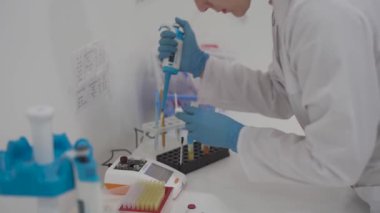 Kan analizi sırasında pipetli bir tıbbi laboratuvar asistanı. Hastane laboratuarlarındaki ekipmanlar. Hematolojik inceleme için damlatıcıyla araştırma görevlisi. Modern laboratuvarda bilim adamı..
