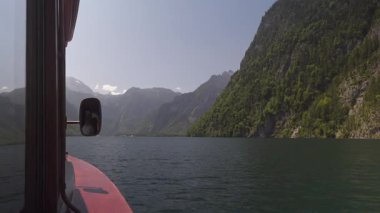 Koenigssee Gölü 'nde sakin bir tekne gezisi. Gemideki görüntüler Watzmann gibi görkemli dağları ve Berchtesgaden Ulusal Parkı 'nın temiz ve yeşil sularını gösteriyor.