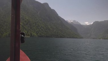 Koenigssee Gölü 'nde sakin bir tekne gezisi. Gemideki görüntüler Watzmann gibi görkemli dağları ve Berchtesgaden Ulusal Parkı 'nın temiz ve yeşil sularını gösteriyor.