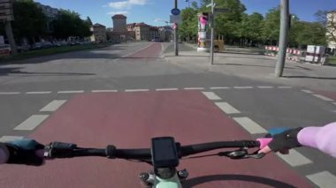 Münih şehir merkezinde tarihi Isartor kapısının yanındaki kırmızı bisiklet yolunda pov çekimi. Şehir yaşam tarzı, çevre taşımacılığı ve güneşli bir yaz gününde Bavyera, Almanya 'yı gezmek. Munchen fahrrad