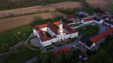 Kloster Schaeftlarn ve tarihi Praelatengarten parkının tepeden aşağı manzarası. Güney Almanya 'da Barok mimarisi, çiçek açan doğa ve panoramik insansız hava aracı perspektifi ile manzara manastırı kompleksi. 
