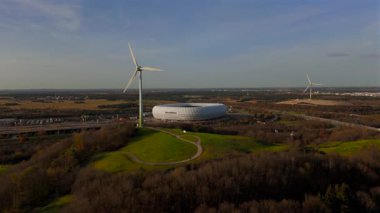 Rüzgâr türbinli Froettmaninger Mullberg 'in hava görüntüsü ve Münih' teki Allianz Arena 'nın net bir görüntüsü. Freimann rüzgar türbini ve Münih futbol arenasının kuş bakışı perspektifi. 