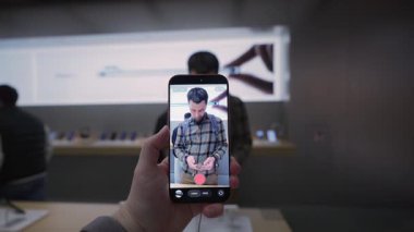 2 Ekim 2025. Münih, Almanya. Apple Store Münih 'te yeni iPhone Pro kamerasını keşfeden kadın müşteri. Modern sancak gemisi akıllı telefonu, fotoğraf ve video yakalama, ön sipariş ve premium Apple deneyimi