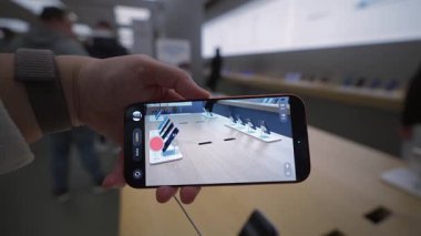 2 Ekim 2025. Münih, Almanya. Apple Store Münih 'te yeni iPhone tutan kadın eli. Kamera önizleme ekranda, gelişmiş fotoğraf ve video teknolojisi, amiral gemisi fırlatma, Almanya 'da ön sipariş