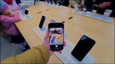 2 Ekim 2025. Münih, Almanya. Kadın müşteri, Apple Store Almanya 'da yeni iPhone kamerasını test ediyor. Ekrandaki kamera önizlemesi, yenilikçi fotoğraf ve video çekimi, amiral gemisi teknolojisi ve ön sipariş 