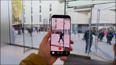 2 Ekim 2025. Münih, Almanya. Sergide yeni iPhone, Apple Store Münih 'te bayan müşteri test kamerası. Sancak gemisi Apple akıllı telefonu, yenilikçi atış seçenekleri, ön sipariş, şık perakende satış