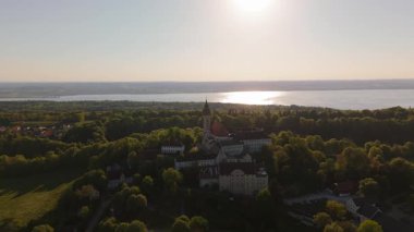 Kloster Andechs 'in ve Ammersee Gölü, Bavyera, Almanya' daki Holy Mountain 'daki kutsal kilisenin insansız hava aracı videosu. Manastır, doğa ve Münih yakınlarındaki kırsal manzaranın günbatımı manzarası