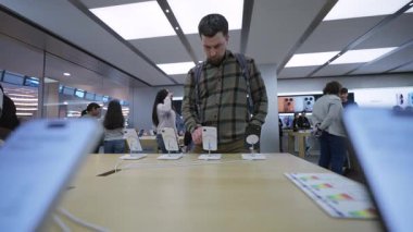 2 Ekim 2025. Münih, Almanya. Müşteri, fırlatma günü Olympia-Einkaufszentrum 'daki Münih Apple Store' da Apple personeline danışmanlık yaparak en son iPhone 17 kadrosunu inceliyor..