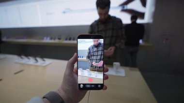 2 Ekim 2025. Münih, Almanya. Kadın, Apple Store Münih 'te yeni iPhone kamerasını test ediyor. Yenilikçi fotoğraf ve video çekimi özellikleri, sancak gemisi akıllı telefonu, ön sipariş seçeneği ve premium Apple deneyimi