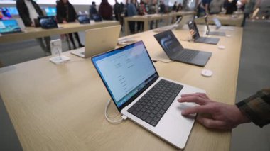 2 Ekim 2025. Münih, Almanya. Olympia-Einkaufszentrum, Münih 'teki modern Apple Store. Müşteri Apple M4 işlemcisi tarafından desteklenen yeni MacBook Pro 2025 çalışan macOS ile etkileşime girer
