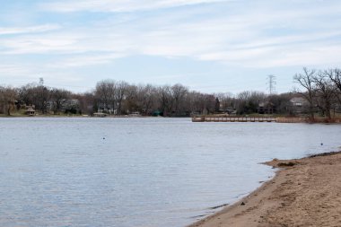 Minneapolis, Minnesota 'da bulutlu bir günde çekilmiş bir göl manzarası.