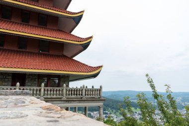 Overview of an Asian Pagoda looking over a forest and city. High-quality photo taken in Reading, Pennsylvania. clipart