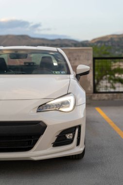 Arka planda dağlar olan bir otoparkın tepesindeki beyaz Subaru BRZ 'nin yakın çekim görüntüsü. Salt Lake City, Utah 'da çekilmiş kaliteli bir fotoğraf.