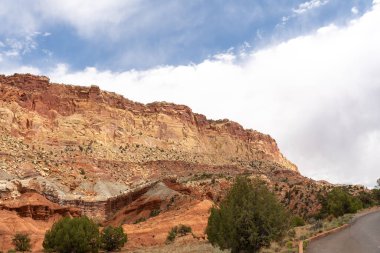 A cloudy and sunny view of red rocks at Capitol Reef National Park in Utah. A high-quality photo taken near Fruita, Utah. clipart