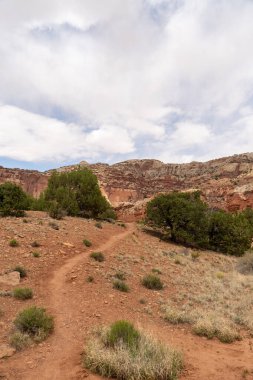 Utah 'taki Capitol Reef Ulusal Parkı' ndaki kırmızı kayaların bulutlu ve güneşli manzarası. Fruita, Utah yakınlarında çekilmiş kaliteli bir fotoğraf..