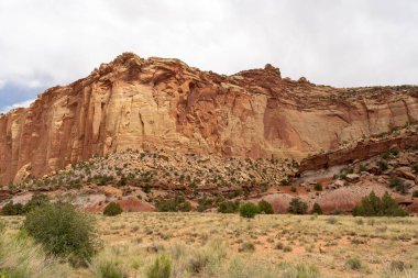 Utah 'taki Capitol Reef Ulusal Parkı' ndaki kırmızı kayaların bulutlu ve güneşli manzarası. Fruita, Utah yakınlarında çekilmiş kaliteli bir fotoğraf..