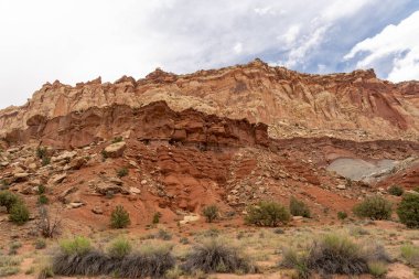 Utah 'taki Capitol Reef Ulusal Parkı' ndaki kırmızı kayaların bulutlu ve güneşli manzarası. Fruita, Utah yakınlarında çekilmiş kaliteli bir fotoğraf..