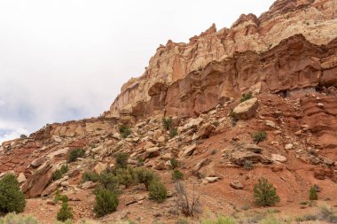 A cloudy and sunny view of red rocks at Capitol Reef National Park in Utah. A high-quality photo taken near Fruita, Utah. clipart