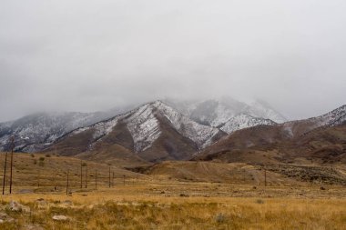 A stunning scenic view of the Stansbury Mountain range on a cloudy day taken from Bates Canyon Trailhead. A high-quality photo taken near Tooele, Utah. clipart