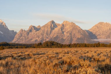 Altın Saat sırasında ve güneşli bir günde insanların olmadığı Teton Dağı 'nın çarpıcı manzarası. Grand Teton Ulusal Parkı, Wyoming 'de çekilmiş kaliteli bir fotoğraf.