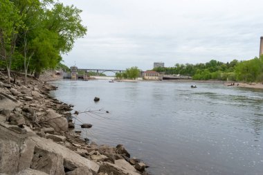 Scenic view of the Mississippi River near Minnehaha Falls, Minnesota. The calm waters and lush green landscape create a tranquil and picturesque setting, showcasing the rivers natural beauty. clipart