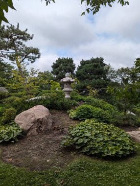 Como Regional Park 'ın sakin bahçesinde bir taş fener, yemyeşil bir yeşillik ve sakin bir ortam var. Bu pitoresk ortam huzurlu bir geri çekilme sunuyor ve sonsuz güzelliği sergiliyor..