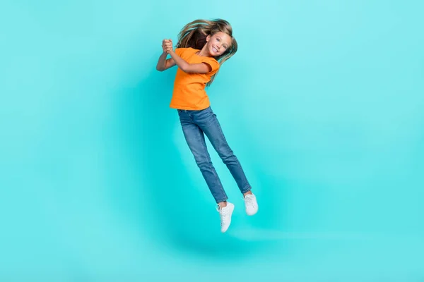 사이즈 전체의 귀여운 여학생 주황색 티셔츠 트램펄린 운동화를 사이언 배경에서 — 스톡 사진