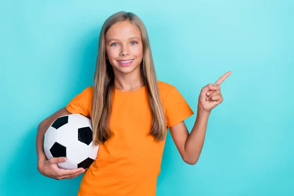 写真のかわいいです小学生女の子ブロンド長い髪プレーヤーサッカーホールドスポーツボールトーナメント指ポイント広告隔離された上のアクアマリン色の背景 — ストック写真