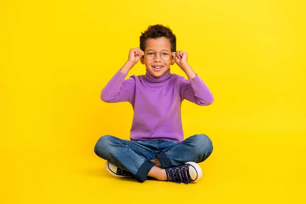 智能心满意足学童的全长肖像坐地板手触摸黄色背景的眼镜 — 图库照片