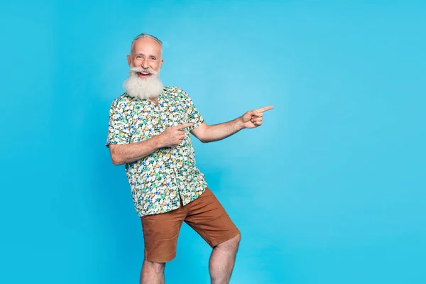 图片上的时髦快乐的男人直接手指空空荡荡的空间广告隔离在蓝色的背景下 — 图库照片