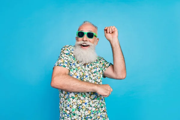 照片上的年长者兴奋的积极外公长灰胡子身穿时髦服装绿色太阳镜正手跳起舞隔离在蓝色背景下 — 图库照片