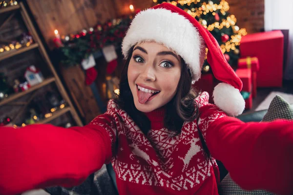 Portrait of excited carefree person make selfie toothy smile showing tongue out christmastime house indoors.